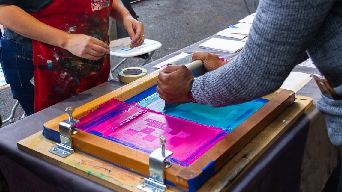 two people screenprinting, only their hands and the screen showing