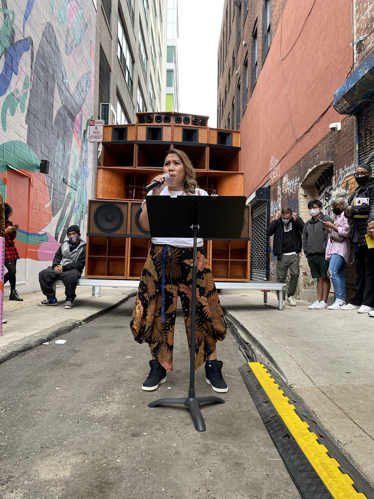 Person speaking on a mic in an alleyway