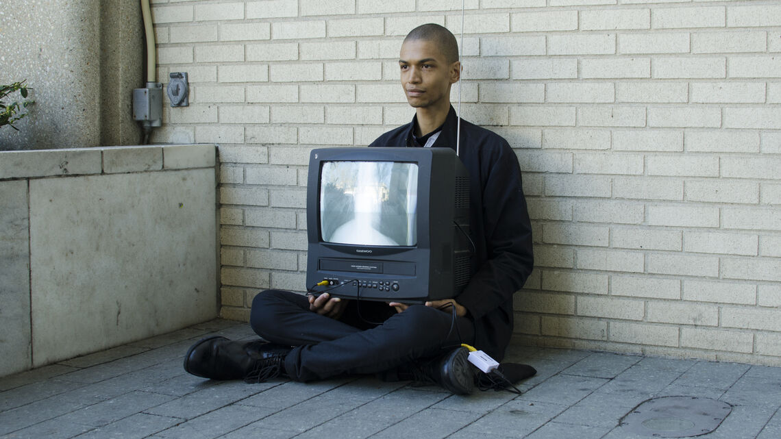 person sitting on floor holding a television