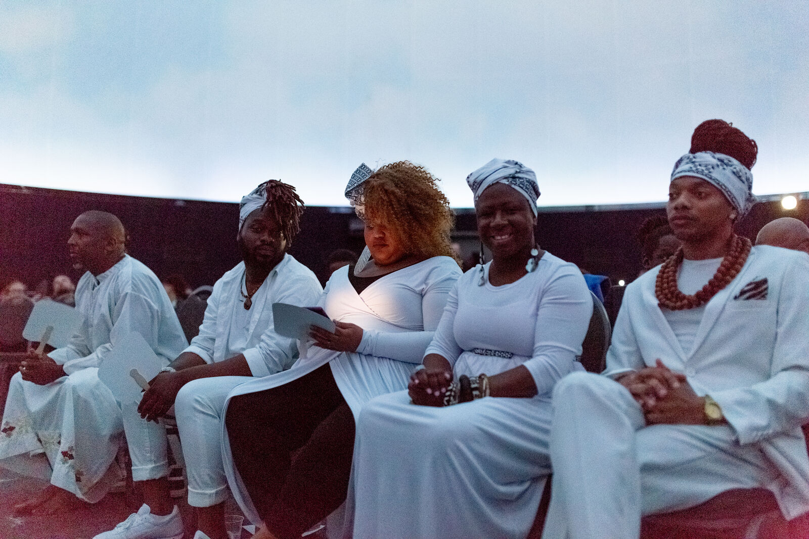 group of individuals sitting, wearing white