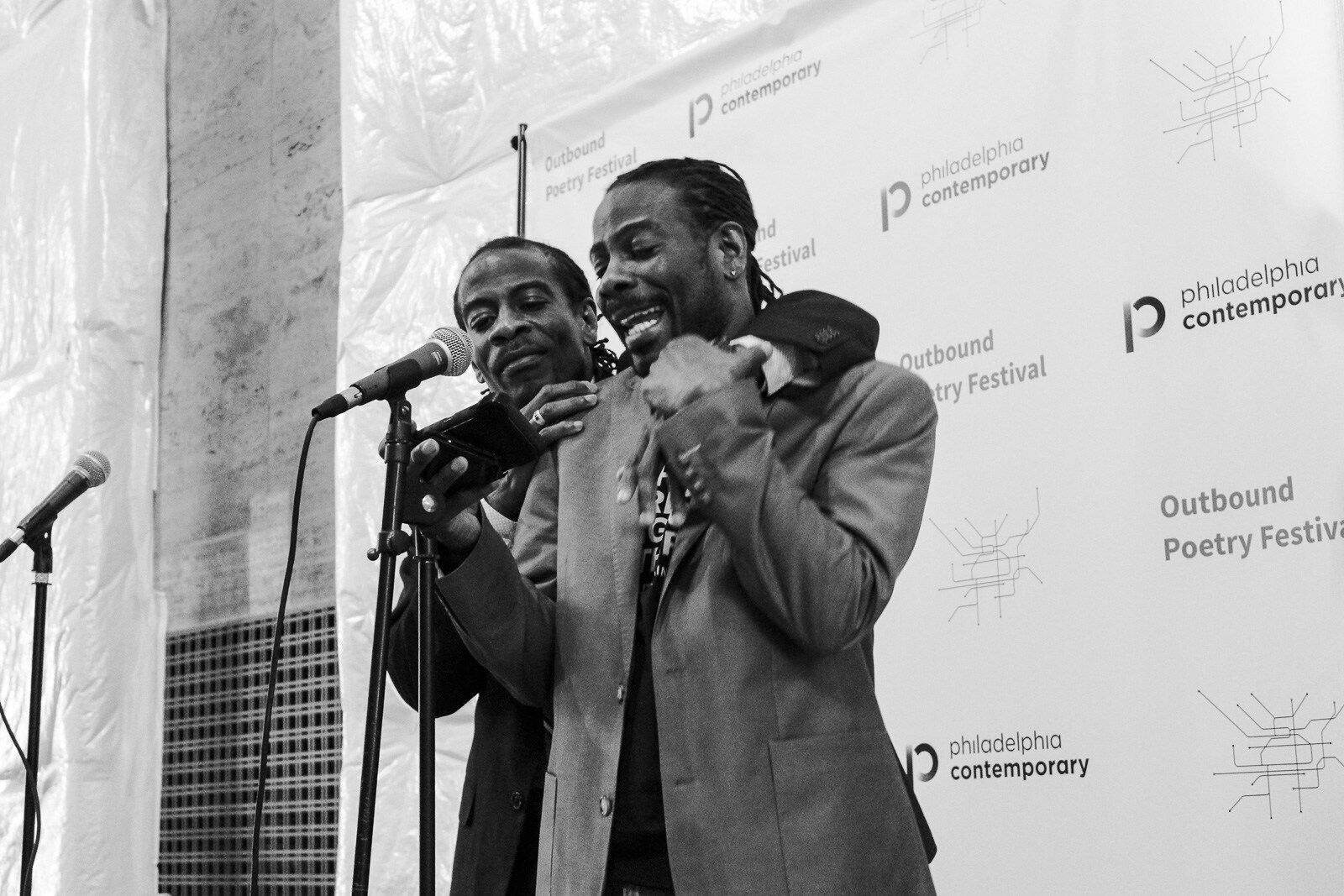 Two men standing at a mic