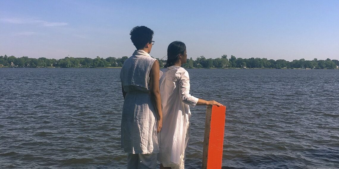 two people wearing white standing on pier