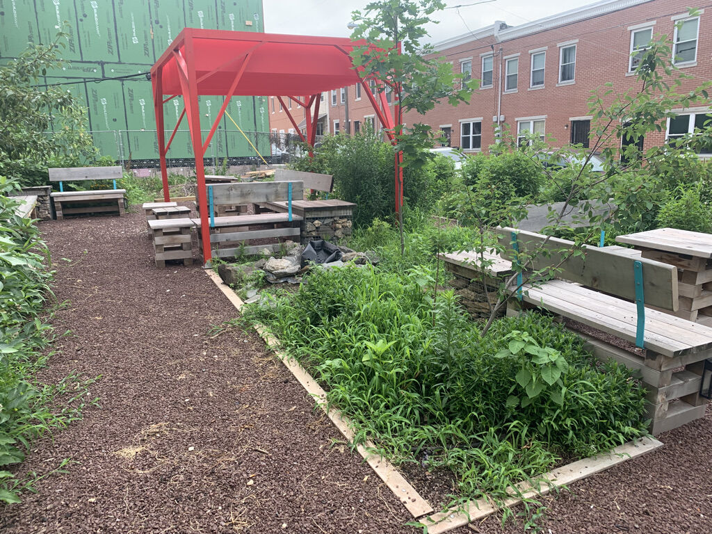 the melon street park after the work done by the youth ambassador program, showing a new pergola, a lush garden, and new seating areas