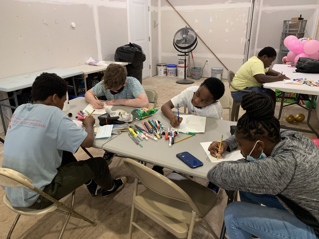 young people drawing and writing at a table