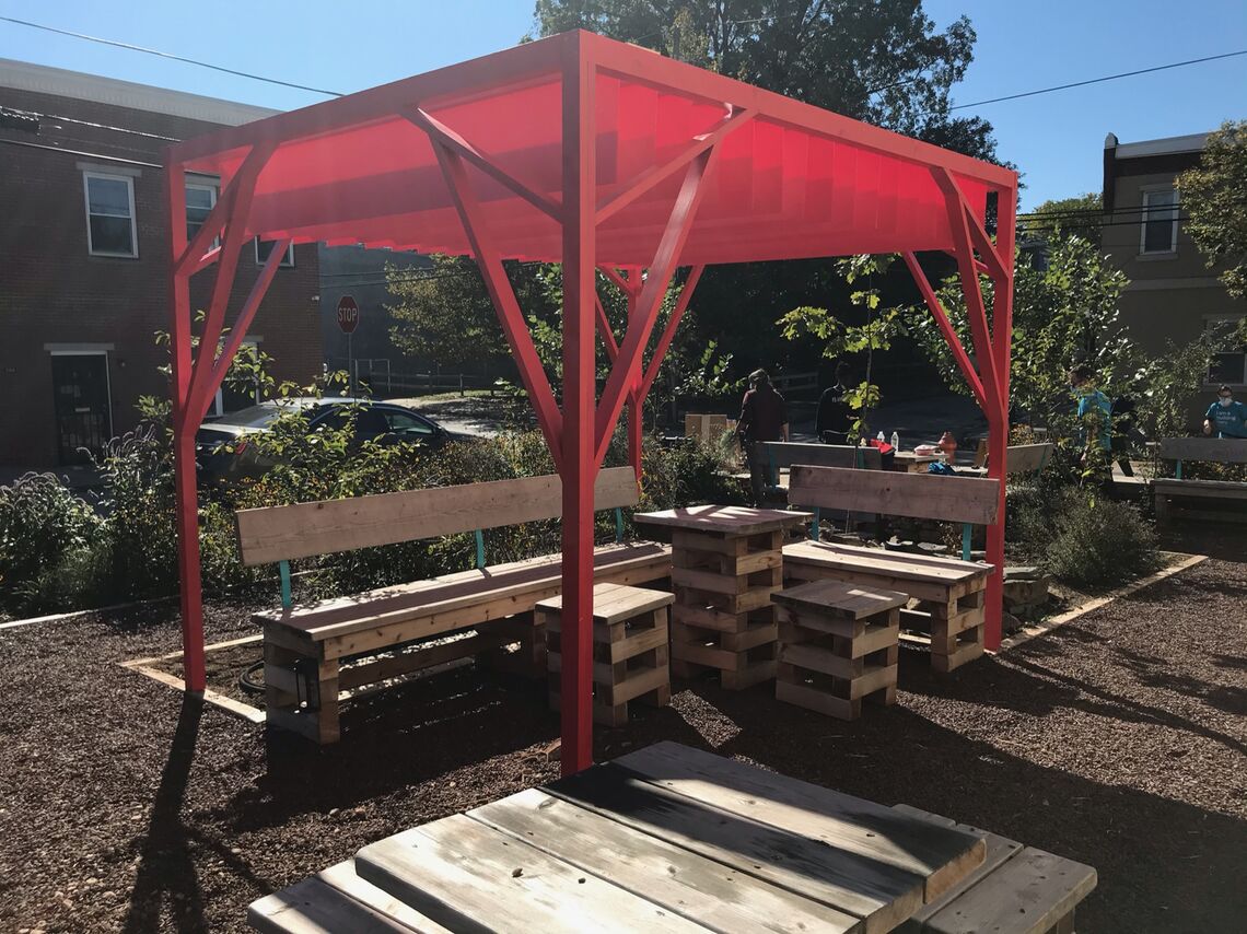 a pergola with seating beneath it