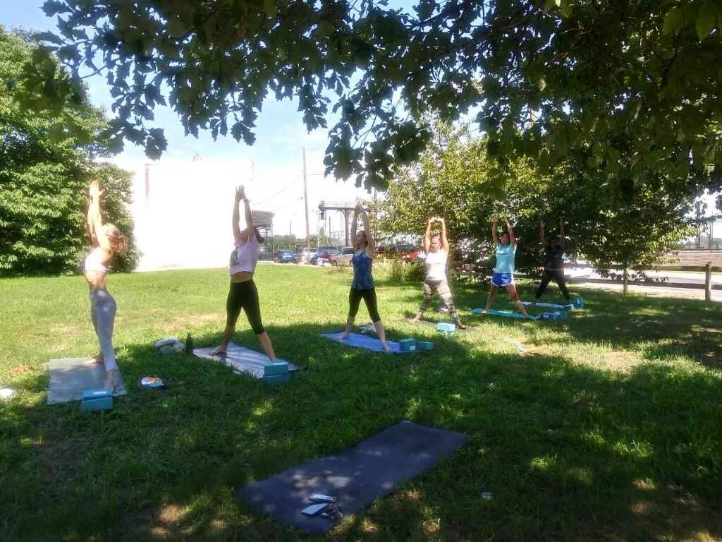 people doing yoga in a park