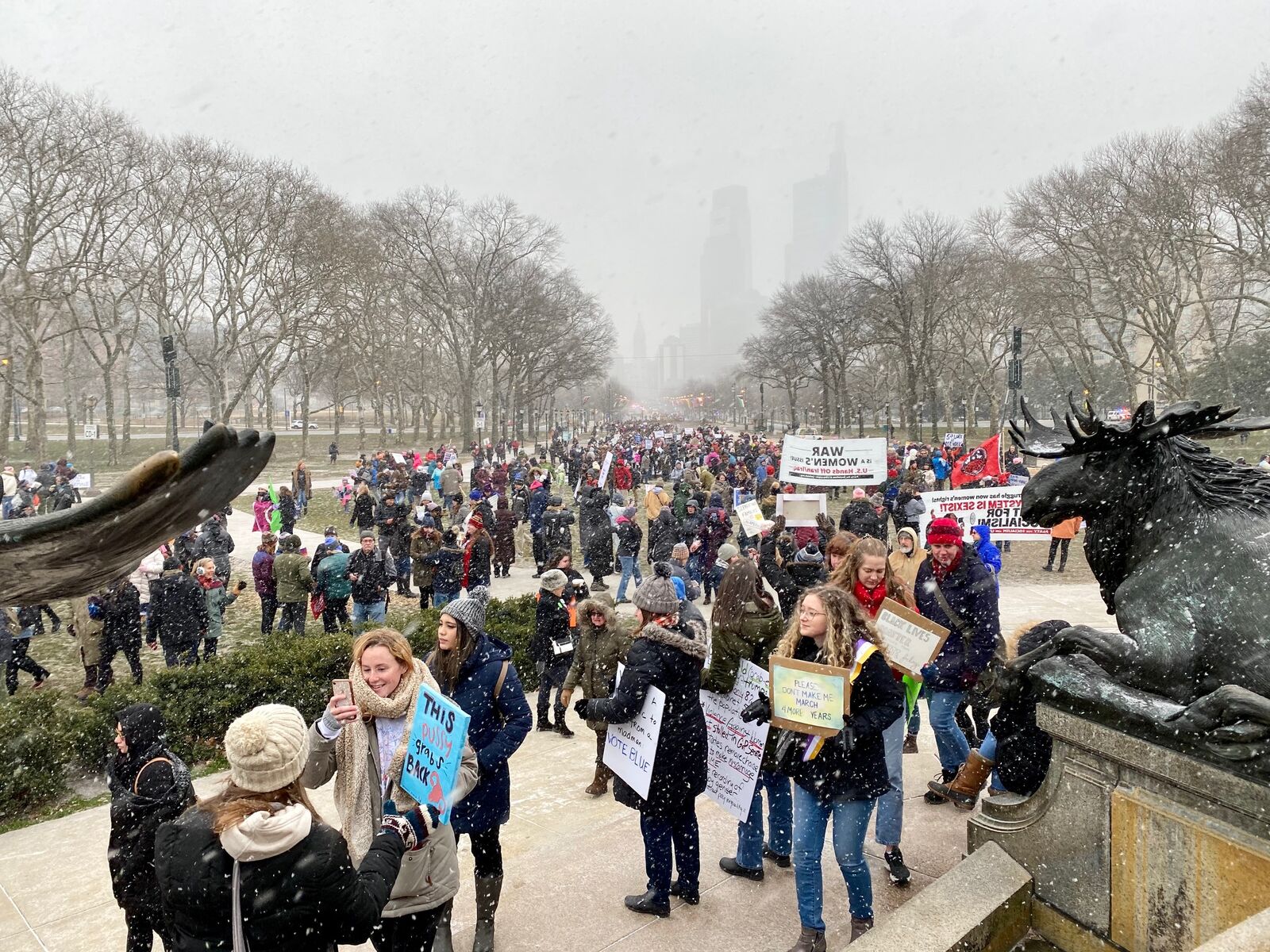 a group of people marching at a women's march in philadelphia