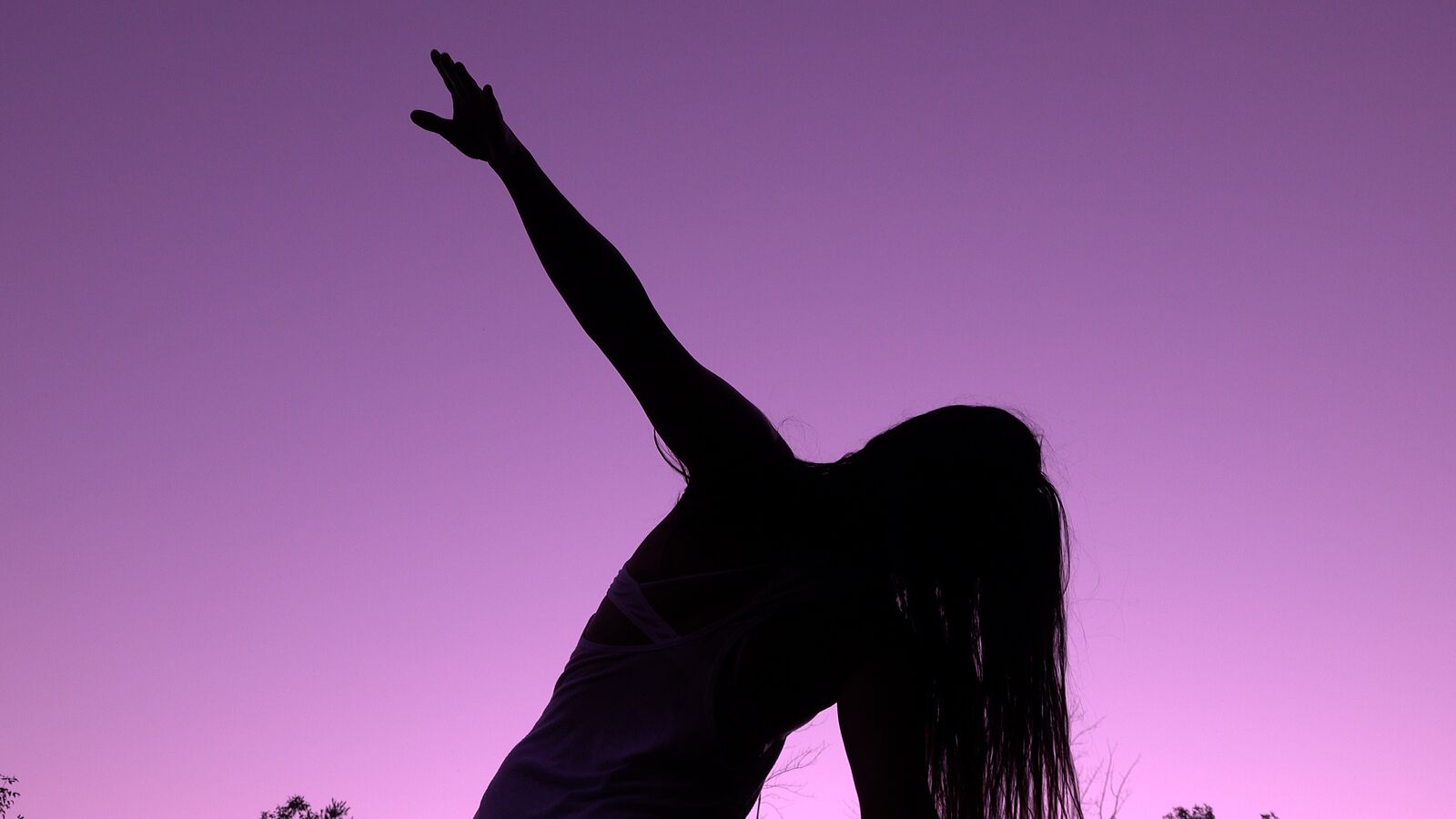 a silhouetted person against a clear purple sky