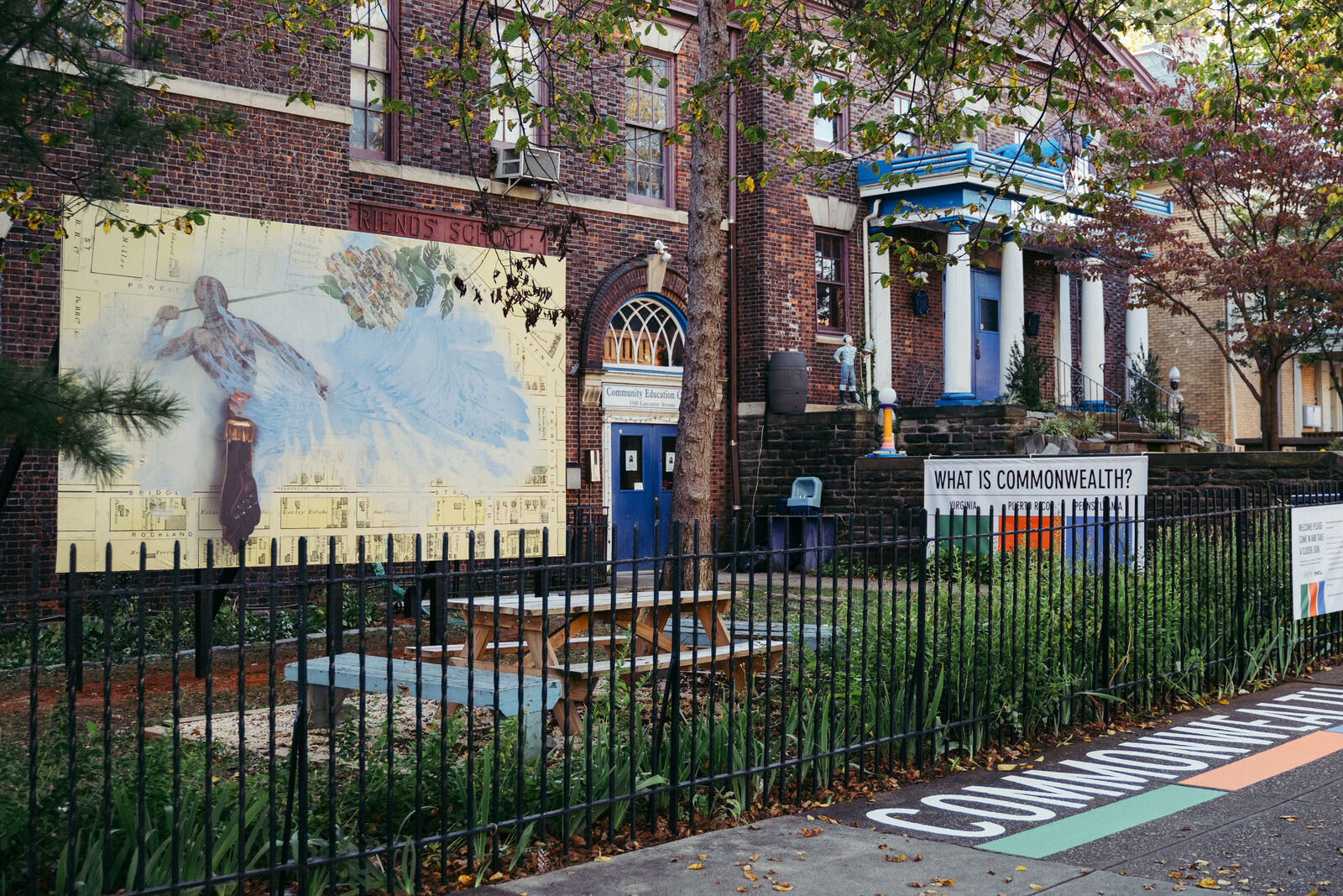 A shot of a mural in context. The mural shows a figure with large wings overlayed on a city plan.