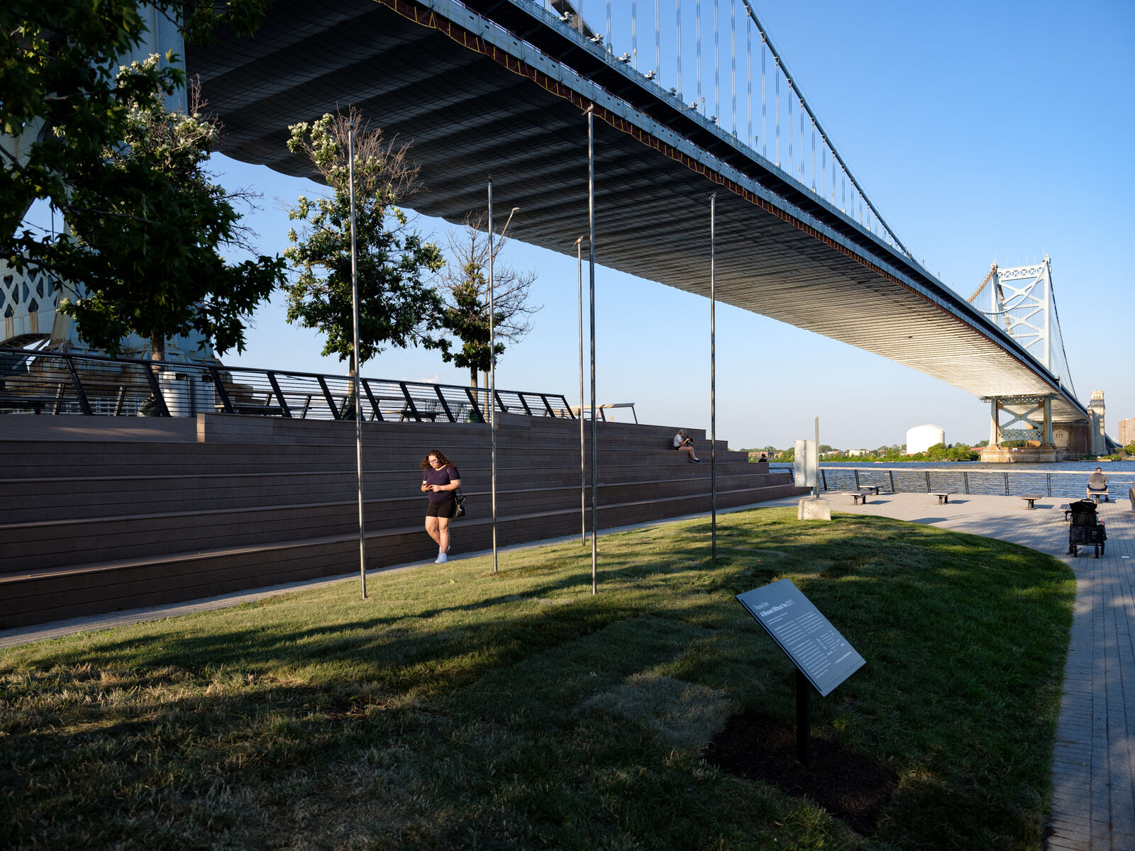 small bronze birds on 12 foot poles, with the riverfront and Benjamin Franklin Bridge in the backround