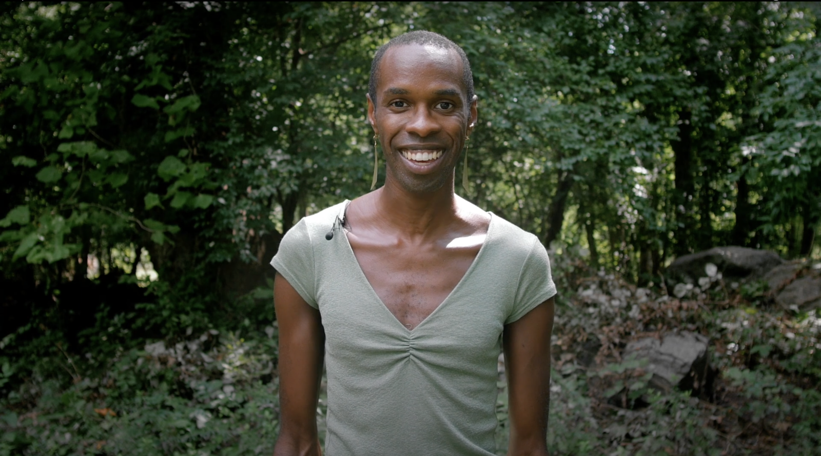 person smiling in the woods for 100 People Listening: How Movement Supports Empathetic Listening project