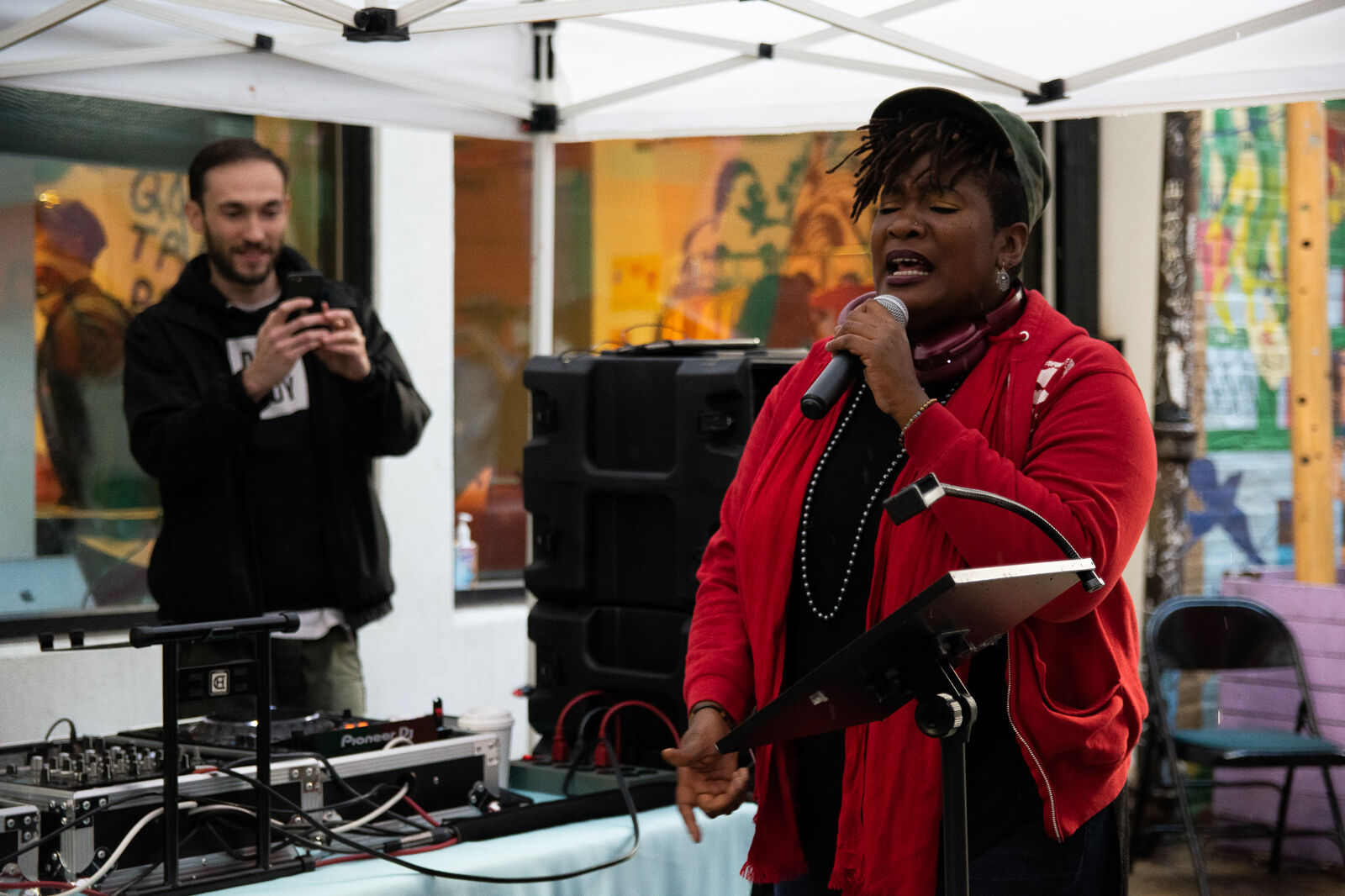 woman on microphone emphatically reads poety