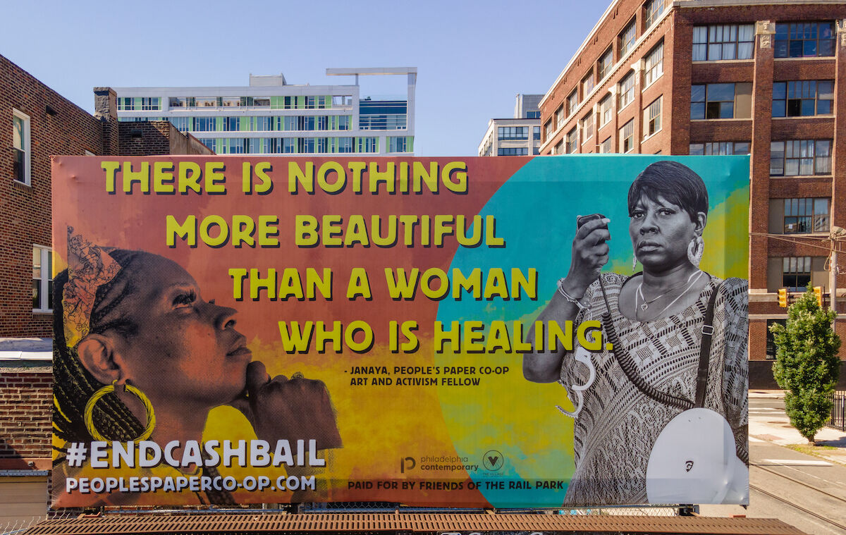 billboard that says "there is nothing more beautiful than a woman who is healing" "end cash bail"