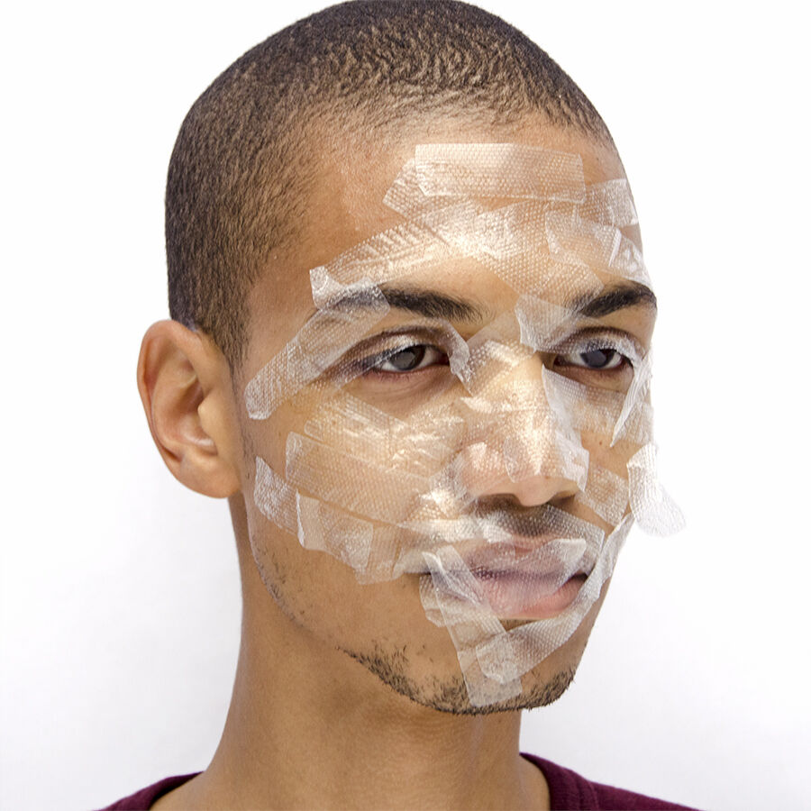 person with scotch tape covering their face with a blank expression