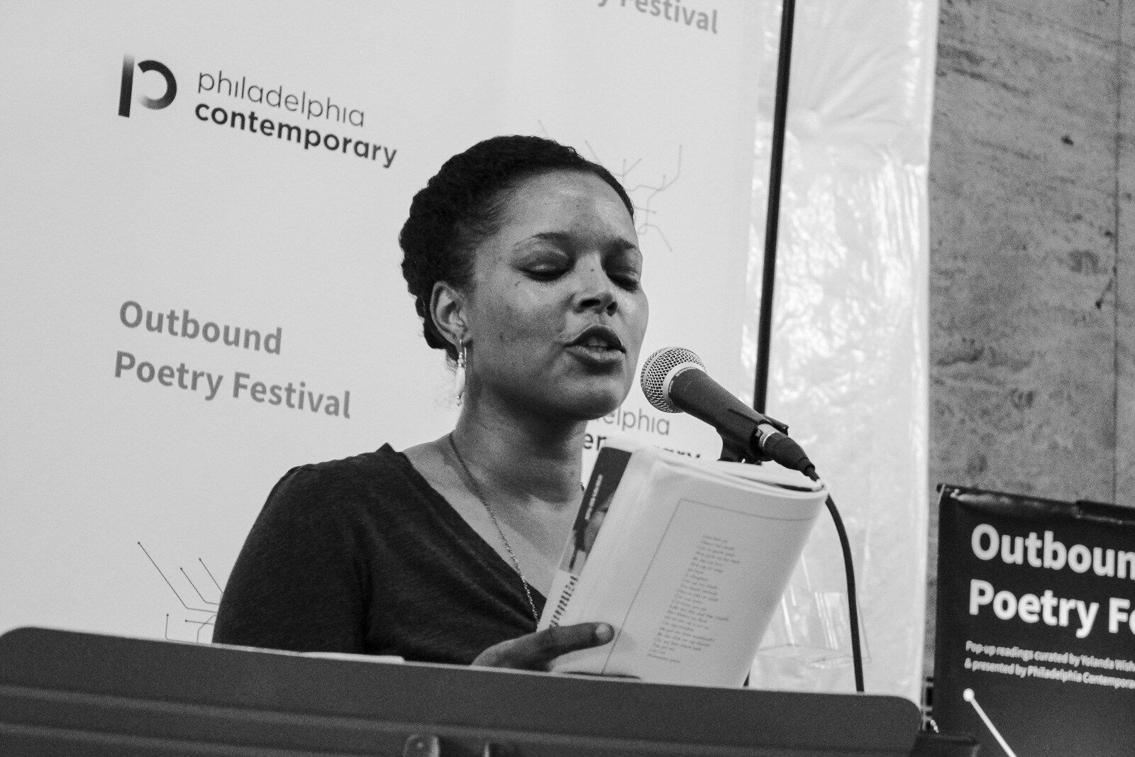 woman reads poetry at a podium