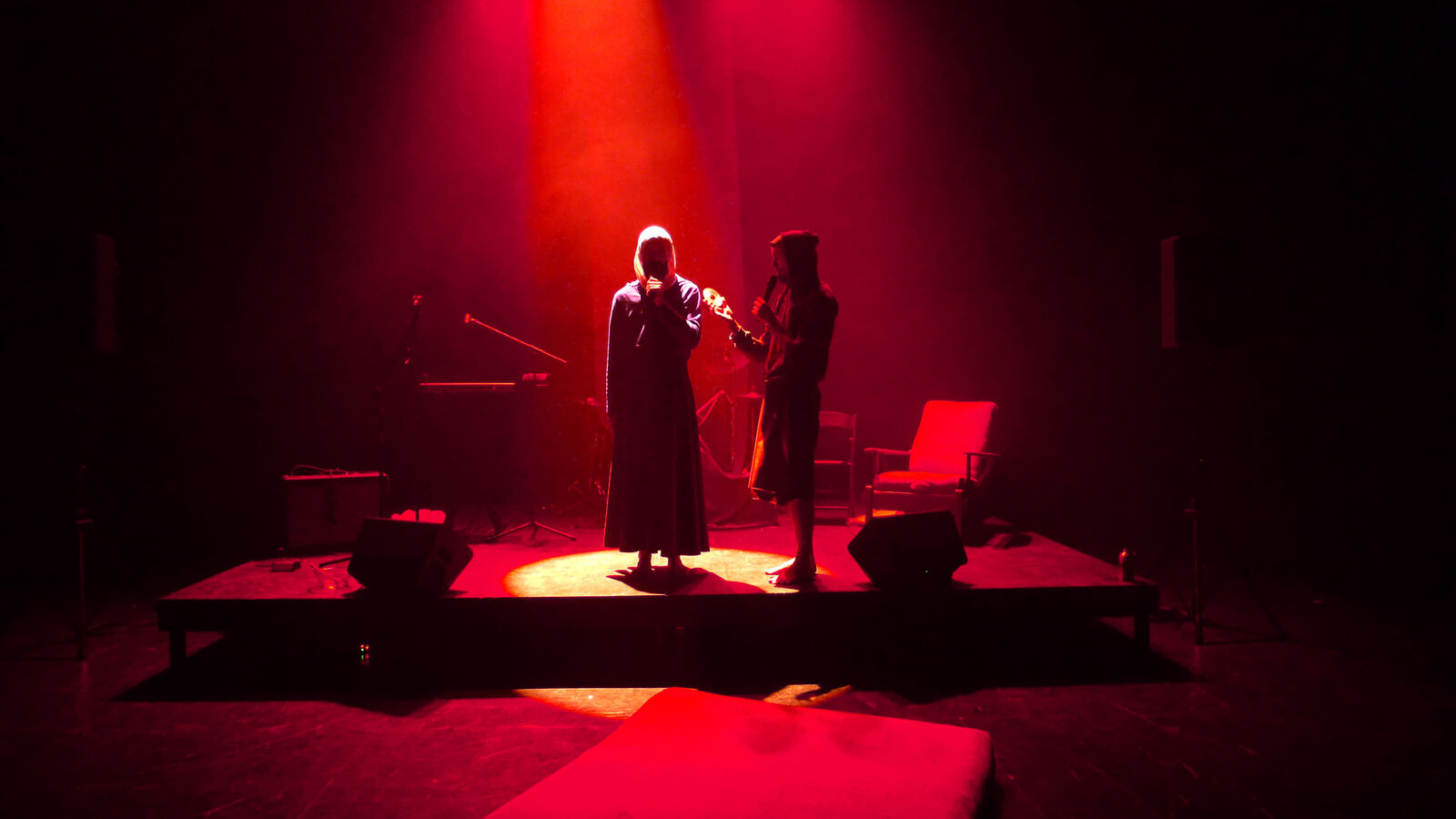 two men silhouetted in a red light perform