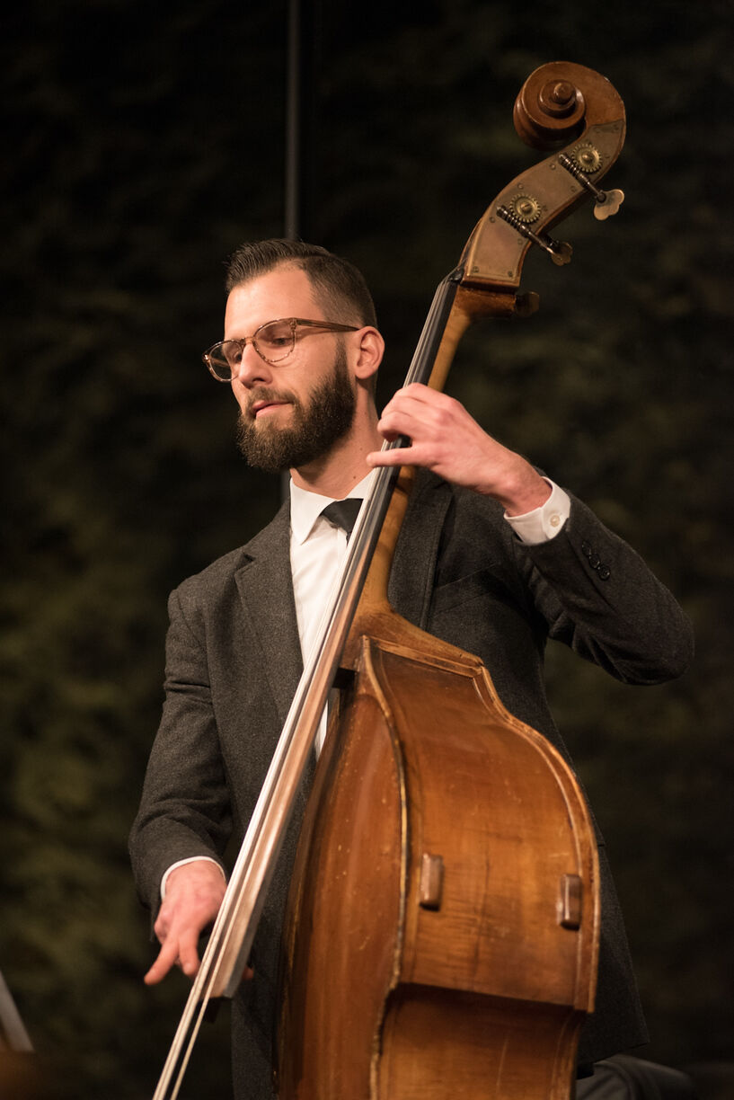 man in suit plays the upright bass