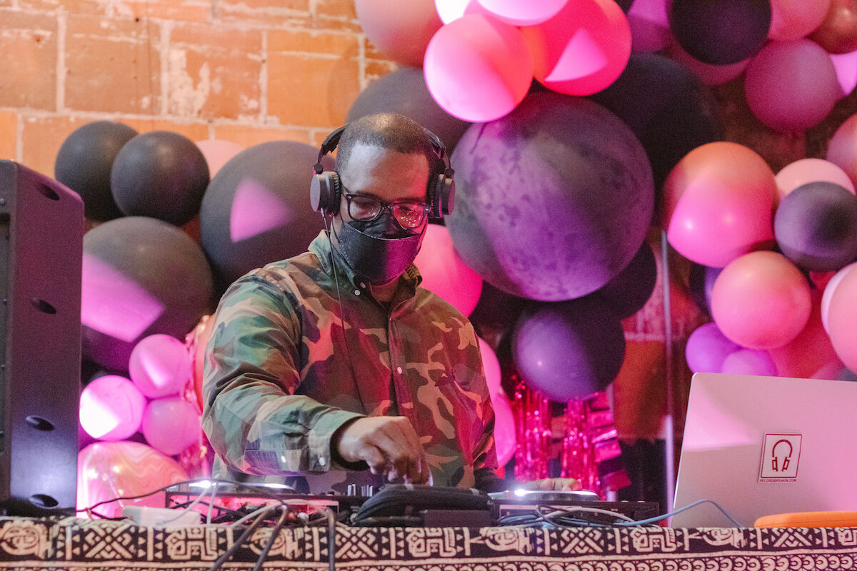 DJ performs in front of colorful balloons