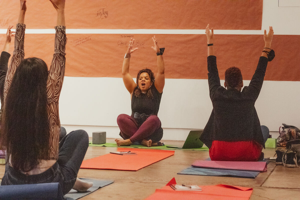 Party attendees perform yoga on colorful mats