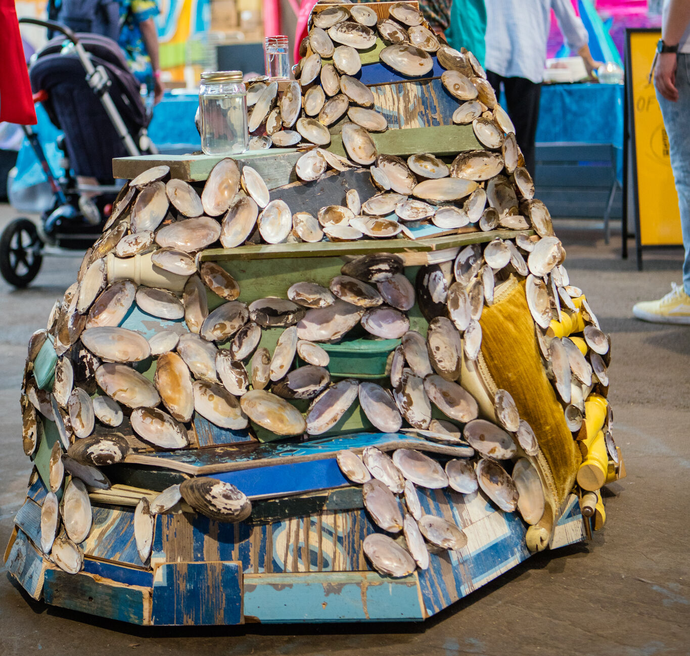 An onlooker observes one of Jean Shin's sculptures featuring reclaimed materials and mussels shells